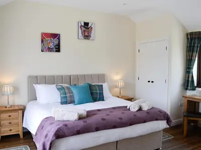 a bedroom with a large bed with towels on it at Bruno's Bothy in Wigton