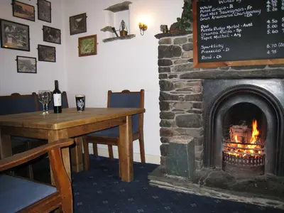 a fireplace in a room with a table and a table and a table at The Langstrath Country Inn in Keswick