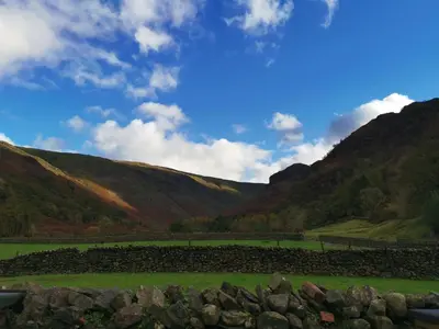 a field with rocks in front of a mountain at The Langstrath Country Inn in Keswick