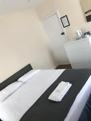 a white bed with a napkin on top of it at Glenfaba Guest House in Douglas