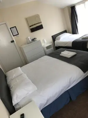 a hotel room with two beds and a window at Glenfaba Guest House in Douglas