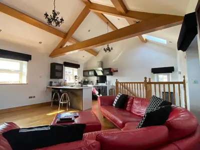 a living room with a red leather couch at Saddleback Penthouse in Penrith