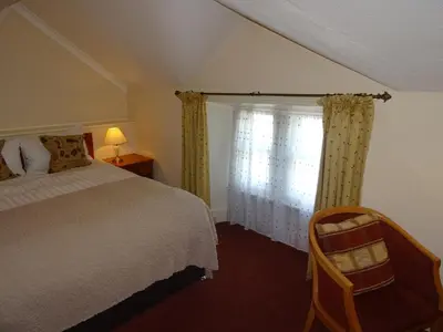 a bedroom with a bed and a window with curtains at Lutwidge Arms in Holmrook