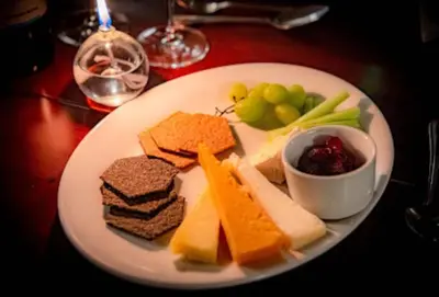a plate of food with cheese and fruit on a table at The Red Admiral Gosforth CA20 1BP in Seascale
