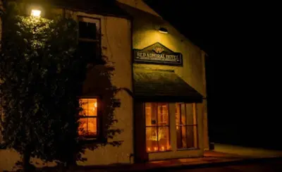 a building with a sign on the side of it at night at The Red Admiral Gosforth CA20 1BP in Seascale