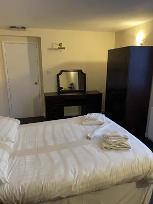 a bedroom with a bed with a dresser and a mirror at The Red Admiral Gosforth CA20 1BP in Seascale