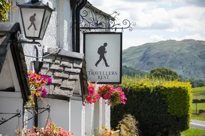 a sign on the side of a building with flowers at The Traveller's Rest in Grasmere