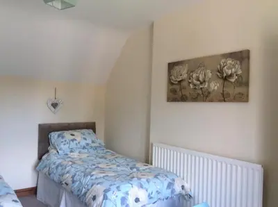 a bedroom with a bed and a painting on the wall at St Matthews cottages in Allonby