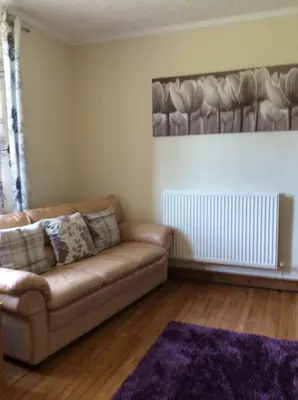 a living room with a couch and a rug at St Matthews cottages in Allonby