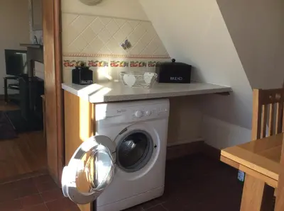 a washing machine in a kitchen with a counter at St Matthews cottages in Allonby
