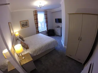 a hotel room with a bed and a window at Rivendell Guest House in Keswick