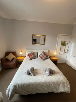 a bedroom with a large bed with two towels on it at Rivendell Guest House in Keswick