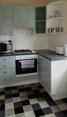 a kitchen with a stove and a checkered floor at Dumfries Central apartment in Dumfries