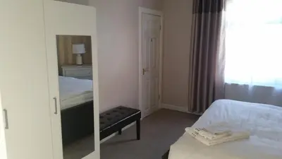 a bedroom with a bed and a mirror at Dumfries Central apartment in Dumfries