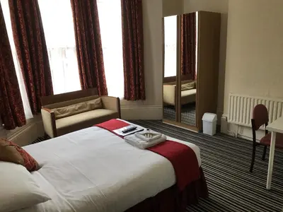 a hotel room with a bed and a mirror at The Island & Fairfield in Douglas