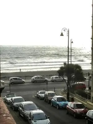 a parking lot with cars parked next to the beach at The Island & Fairfield in Douglas