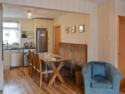 a kitchen with a dining room table and chairs at Saddleback in Keswick