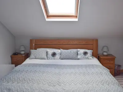 a bedroom with a bed with two pillows and a window at Saddleback in Keswick