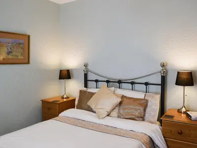 a bedroom with a bed with two night stands and two lamps at Blencathra House in Keswick