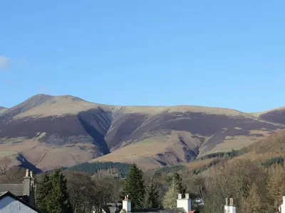 a mountain in the distance with houses and trees at Blencathra House in Keswick