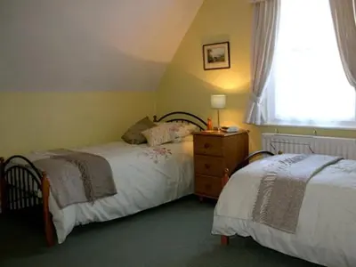a bedroom with two beds and a window at Blencathra House in Keswick