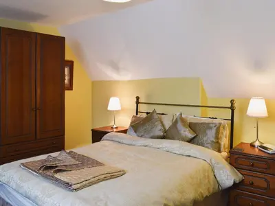 a bedroom with a bed with two lamps and a dresser at Blencathra House in Keswick