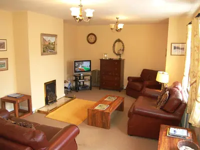 a living room with leather furniture and a television at Topsey Turvey in Keswick