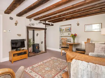 a living room with a tv and a mirror at Bunbury Cottage in Keswick