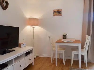 a living room with a table and a desk with a television at Royal Views in Keswick