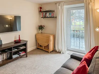 a living room with a couch and a tv at 1 Greta Side Court in Keswick