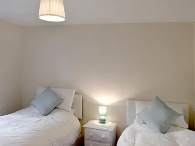 two beds sitting next to each other in a room at 1 Greta Side Court in Keswick