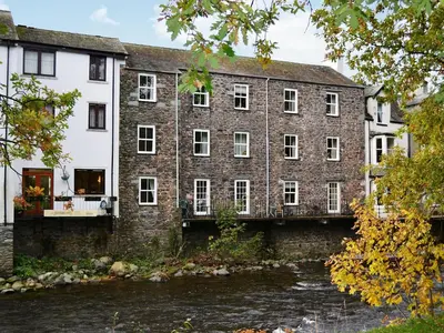 an old brick building next to a river at 1 Greta Side Court in Keswick