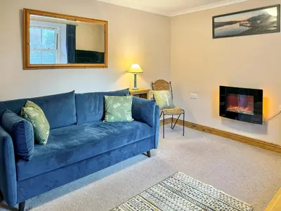 a blue couch in a living room with a fireplace at 2 Greta Side Court in Keswick