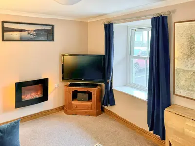 a living room with a flat screen tv and a fireplace at 2 Greta Side Court in Keswick