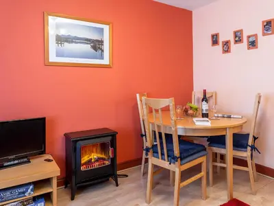 a dining room with a table and a fireplace at Beech Nut in Keswick