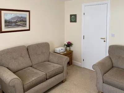 a living room with a couch and two chairs at Ashbrooke- Hewetson Court in Keswick