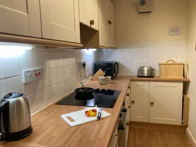 a kitchen with a counter with a cutting board on it at Ashbrooke- Hewetson Court in Keswick