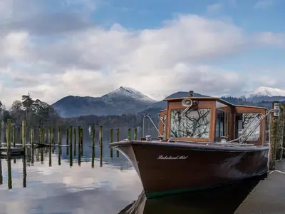 a boat is docked at a dock in the water at Ashbrooke- Hewetson Court in Keswick