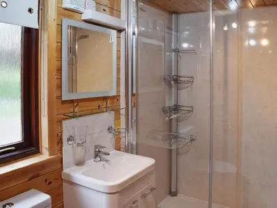 a bathroom with a shower and a toilet and a sink at Ashness in Keswick