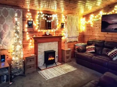 a living room with a fireplace and a couch at Bewick Lodge in Keswick