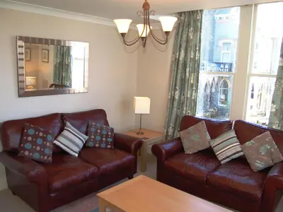 a living room with two leather couches and a table at Brundholme in Keswick