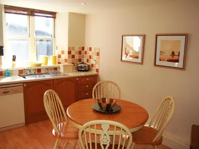a kitchen with a wooden table and chairs and a sink at Brundholme in Keswick