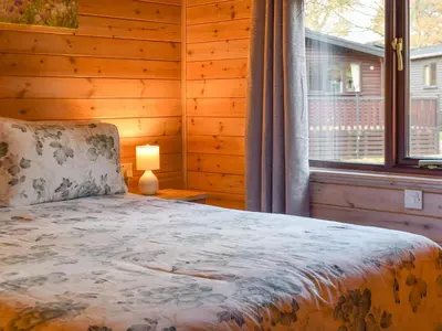 a bedroom with a bed next to a window at Whinny Brow - Burnside Park in Keswick