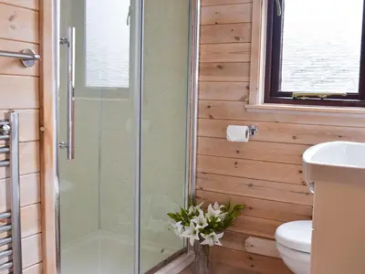 a bathroom with a shower and a toilet and a sink at Whinny Brow - Burnside Park in Keswick