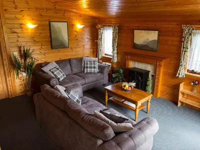 a living room with couches and a fireplace in a log cabin at Whiteside Lodge At Burnside Park in Keswick