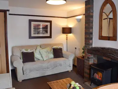 a living room with a couch and a fireplace at Dairy Lodge in Keswick