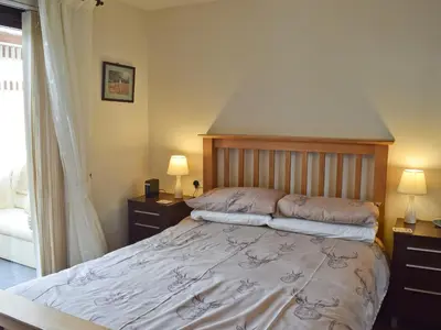 a bedroom with a bed with two night stands and two lamps at Dairy Lodge in Keswick
