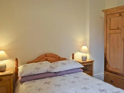 a bedroom with a bed with two night stands and two lamps at Shorley Lodge in Keswick