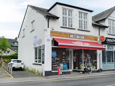 a store with a red awning on a street at Bay Tree in Keswick