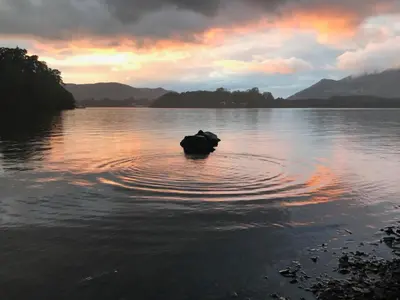 a rock in the middle of a body of water at 3 Catherine Cottages in Keswick